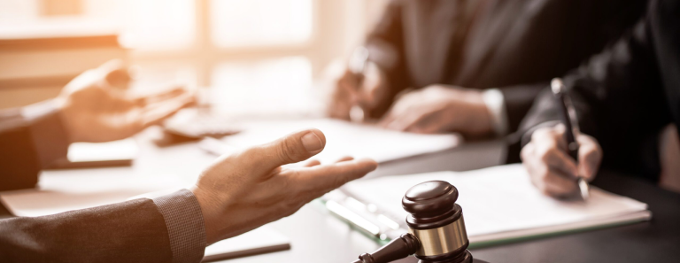 judge and two business lawyers writing on paper